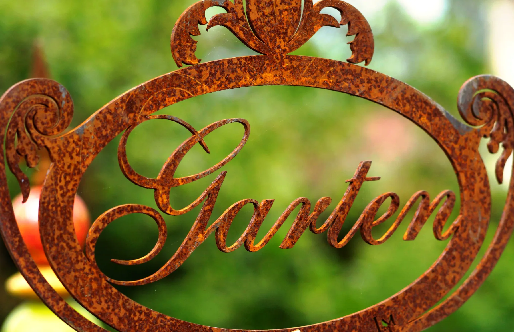 Dekoratives Gartenschild vor frischem Grün