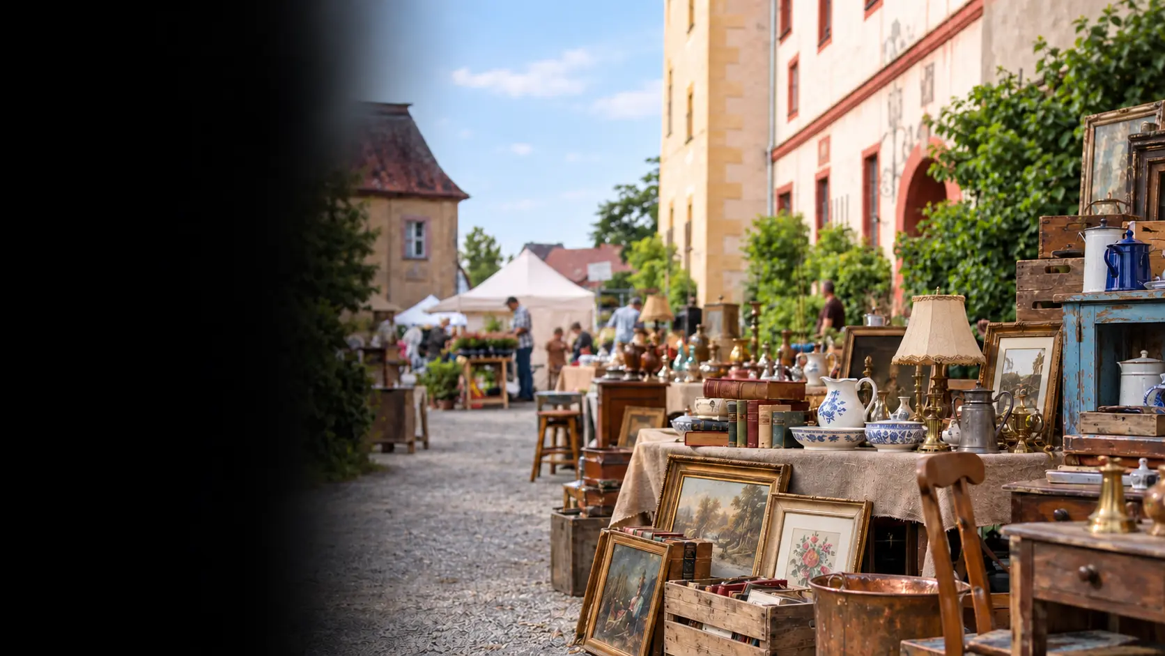 Antiquitäten, Keramik, Bilder und alte Bücher auf Marktständen in einem historischen Schlosshof